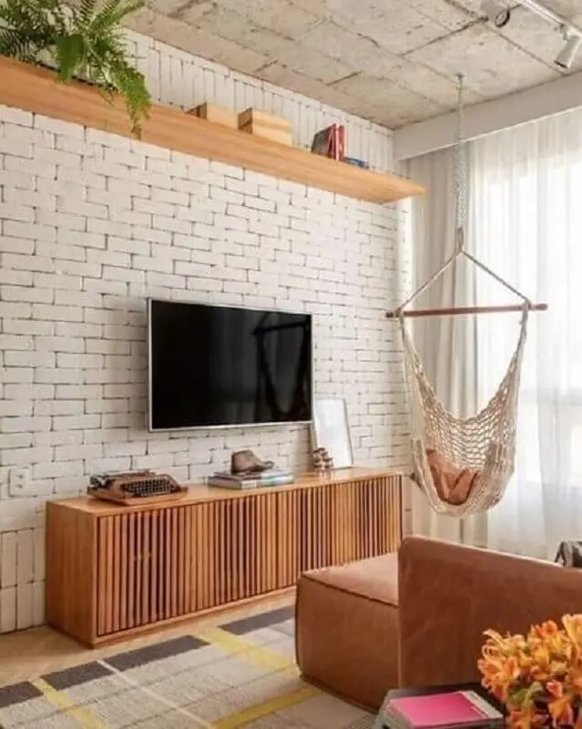 tapete bege para sala de TV com parede de tijolinho Foto Iaza Móveis de Madeira