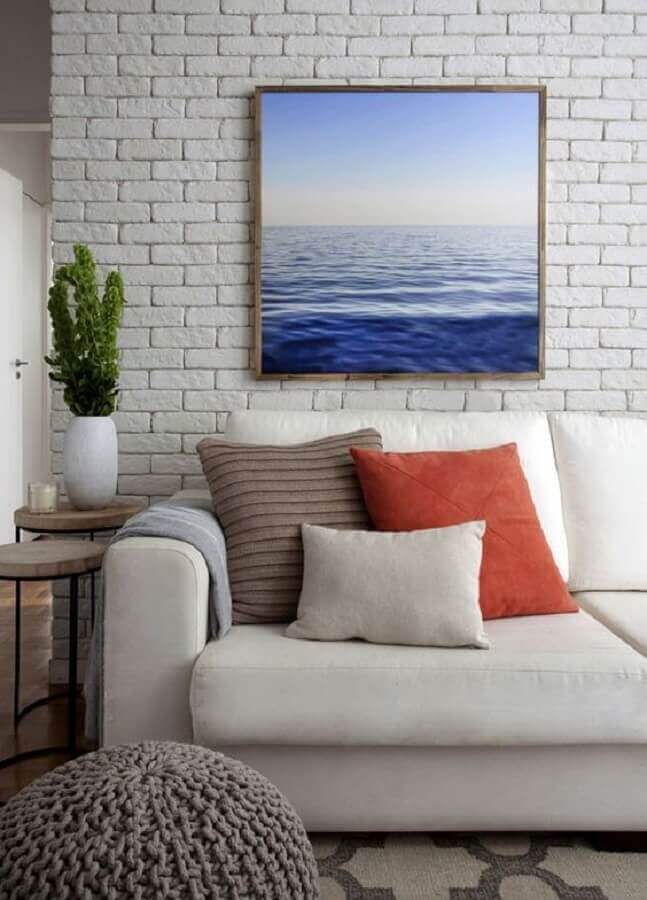 vaso decorativo para sala de estar com parede de tijolinho branca e almofadas coloridas Foto Jeito de Casa