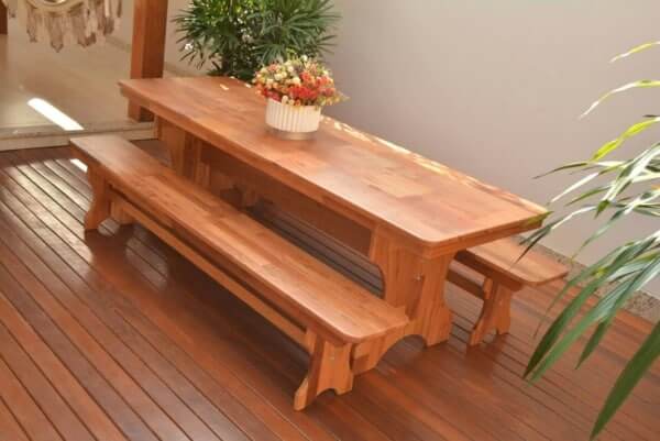 A mesa de Angelim apresenta cores de madeira avermelhada
