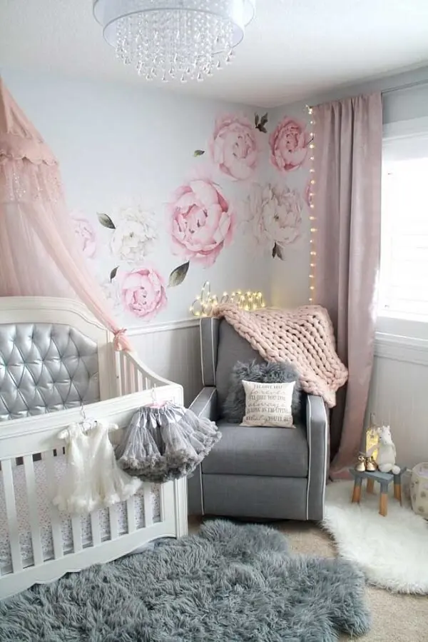 Tons de cinza e rosa se dispersam em vários objetos e móveis do quarto de bebê