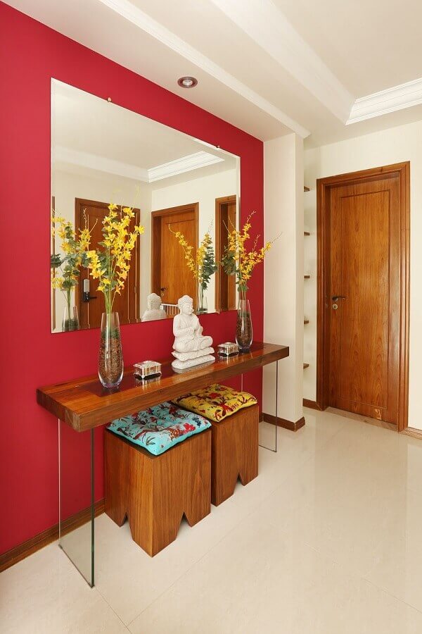 aparador para hall de entrada decorado com parede vermelha e espelho bisotado Foto Jeito de Casa