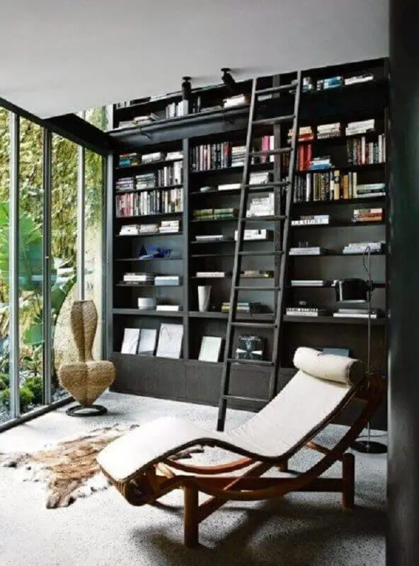 cantinho de leitura decorado com estante preta planejada e poltrona confortável para leitura Foto Next Luxury