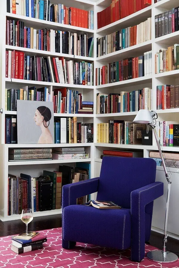 cantinho de leitura planejado com estante branca para livros e poltrona confortável para leitura Foto Vintage & Chic