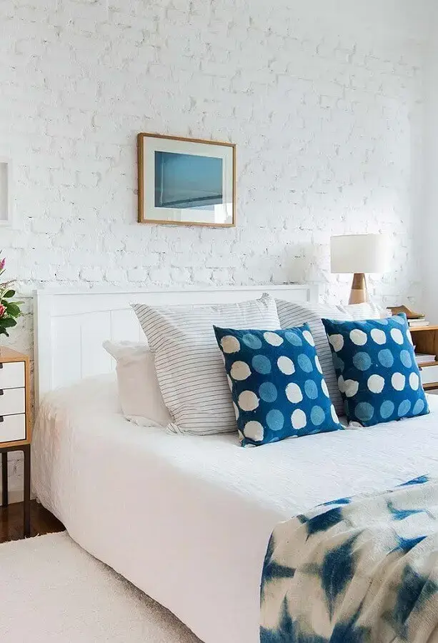 cores claras para quarto de casal com parede de tijolinho branca e almofadas azuis Foto Sua Decoração