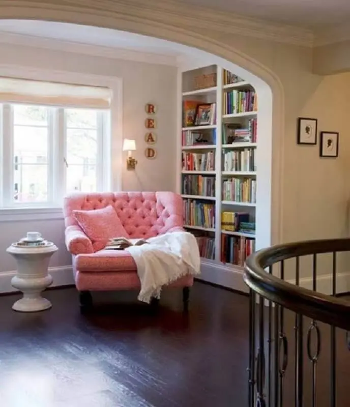decoração clássica com estante de livros planejada e poltrona confortável para leitura cor de rosa Foto Pinterest