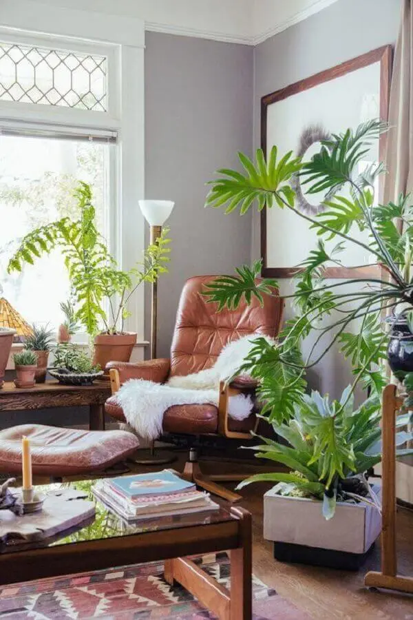 decoração de sala de estar com poltrona de couro e vasos de plantas Foto Archidea
