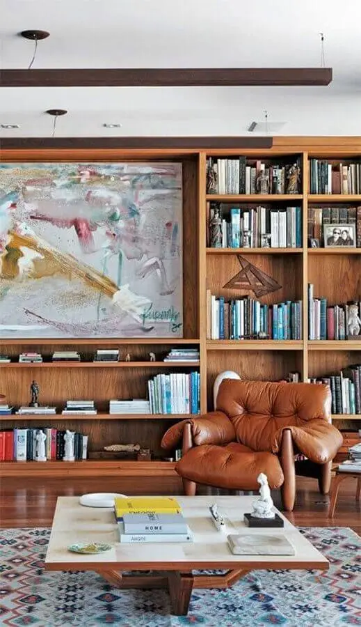 decoração de sala planejada com estante de madeira e poltrona de couro para leitura Foto Pinterest