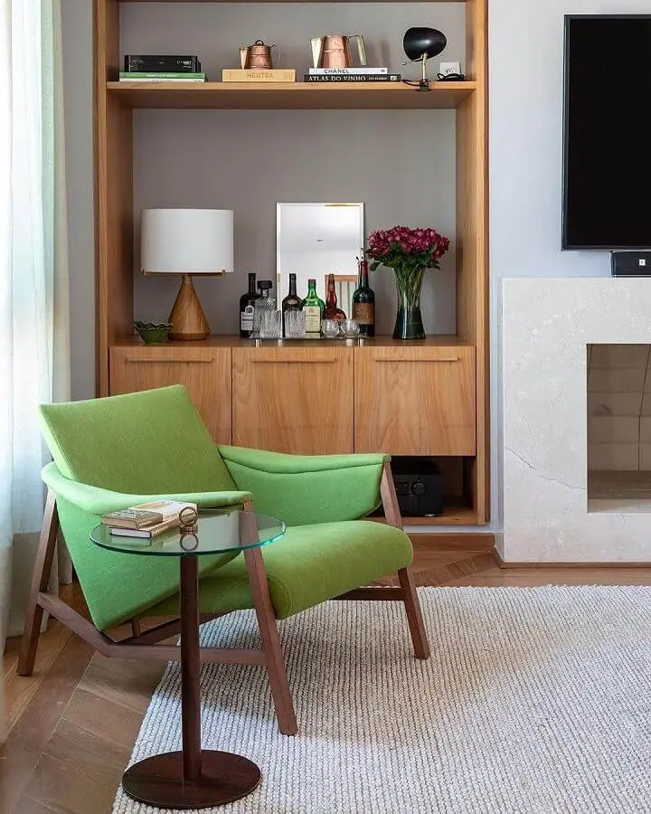 poltrona para leitura verde moderna para sala de TV decorada com estante de madeira Foto Adriana Valle e Patrícia Carvalho