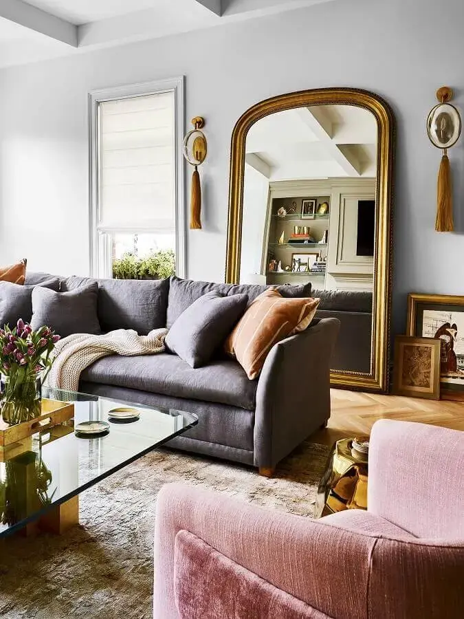 sala de estar decorada com sofá cinza e espelho de chão com moldura Foto Pufik Homes