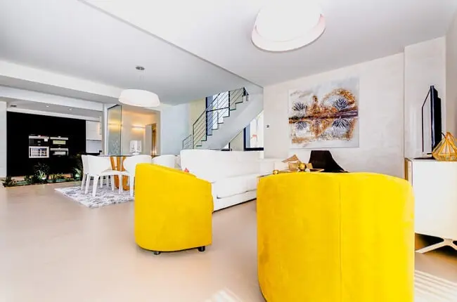 As costas do sofá branco delimita a área da sala de estar nos espaços integrados