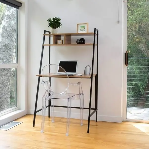 A cadeira de acrílico transparentes se conecta com a estrutura da escrivaninha de ferro e madeira