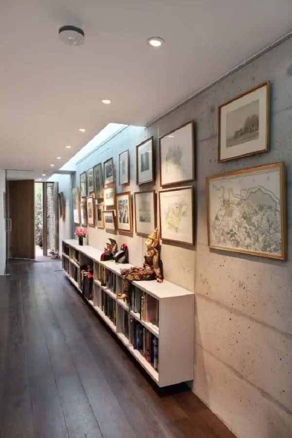 Ambiente decorado com prateleira branca fixada a parede e luminária para corredor interno em formato redondo