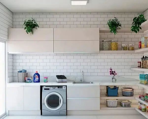 Bancada ampla e revestimento para lavanderia branco decoram o espaço