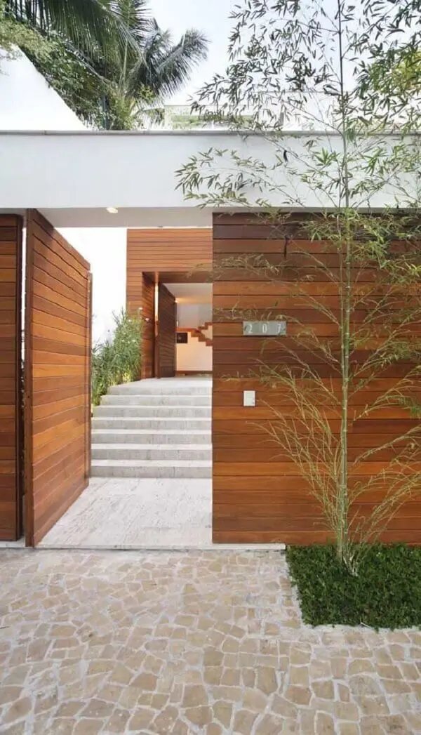 Modelo de muro de frente de casa feito em madeira é durável e traz segurança ao imóvel