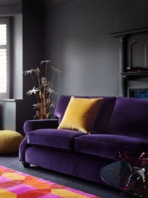 Modelo de sofá roxo escuro em veludo e almofada amarela