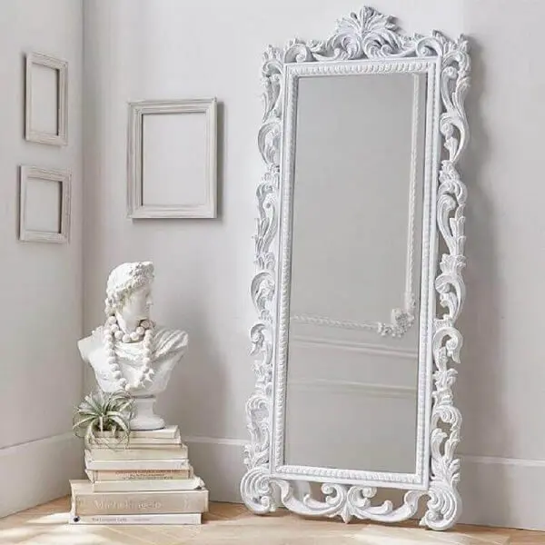 O espelho branco vintage de chão complementa a decoração clean