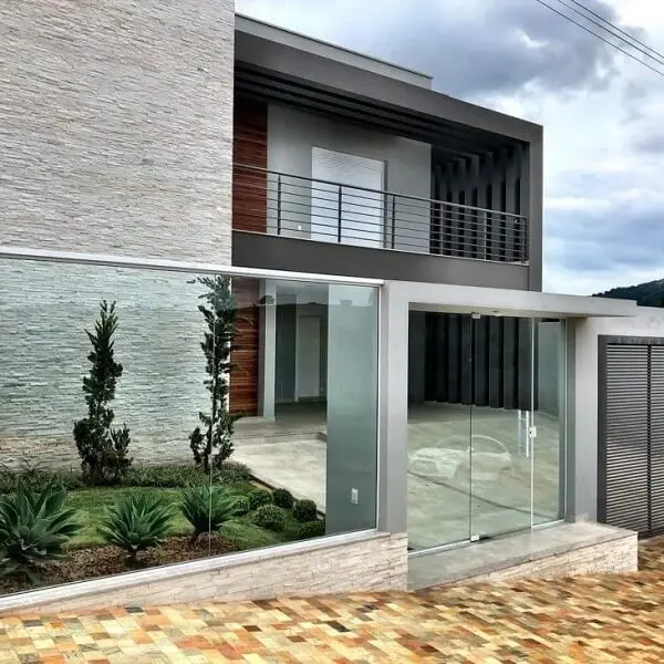 O modelo de frente de muro feito em vidro traz charme para a fachada da casa
