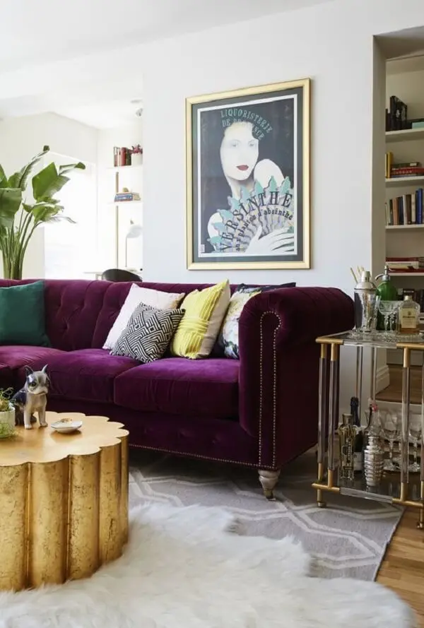 O sofá roxo escuro quebra a neutralidade da decoração desse ambiente