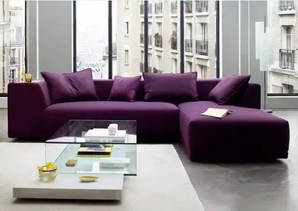 O sofá roxo escuro se destaca na decoração do ambiente