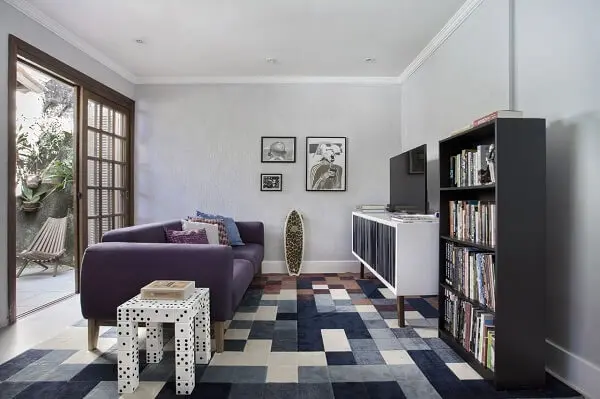 O sofá roxo se encaixa de forma harmoniosa na composição desse espaço