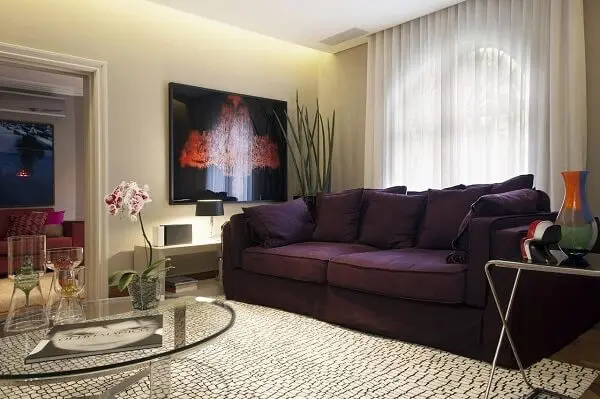 O sofá roxo traz um toque de cor para a decoração da sala de estar