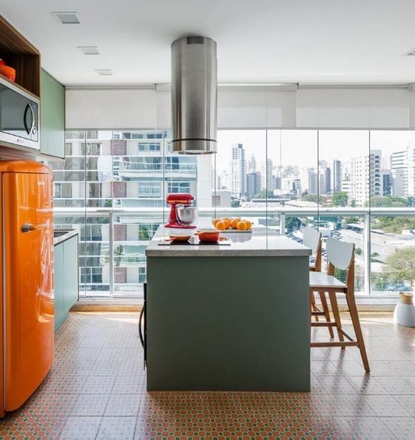 Bancada de cozinha em granito clara com móveis verdes e geladeira laranja 