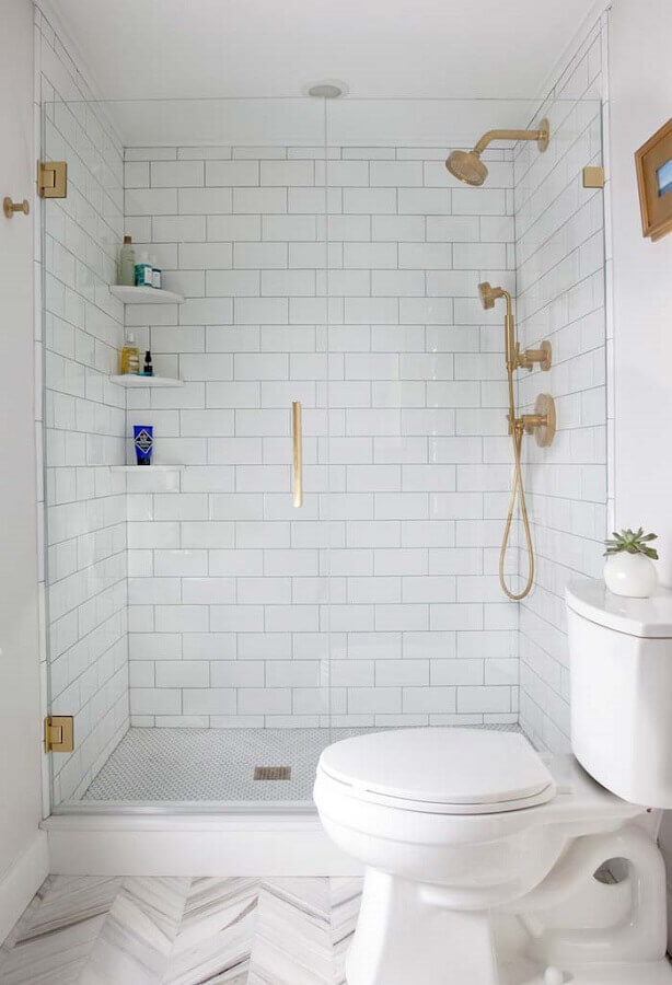 banheiro simples decorado com revestimento branco liso e detalhes em dourado Foto Archidea