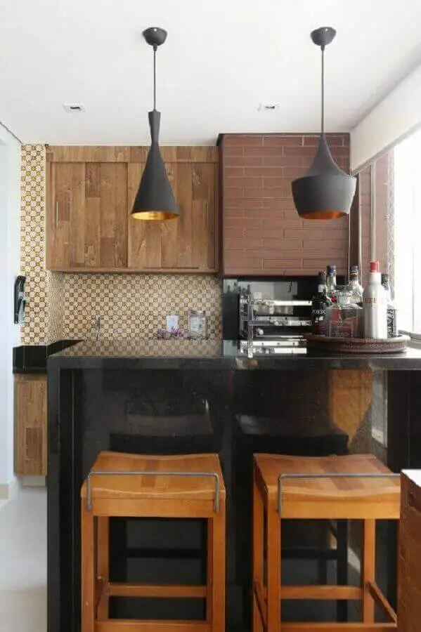 banquetas de madeira para área gourmet pequena decorada com bancada preta Foto Bianchi & Lima Arquitetura