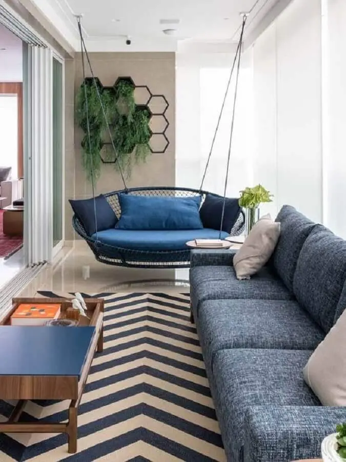 decoração de varanda de apartamento com balanço suspenso e sofá azul Foto Pinterest
