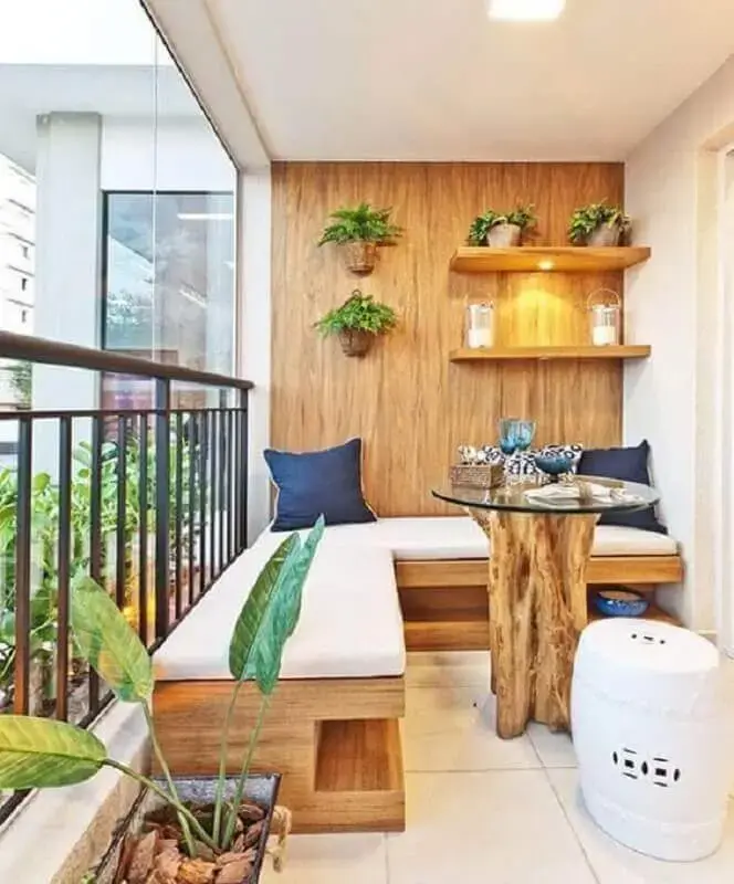 decoração de varanda de apartamento com sofá de canto de madeira e mesa de vidro com base de madeira Foto Pinterest
