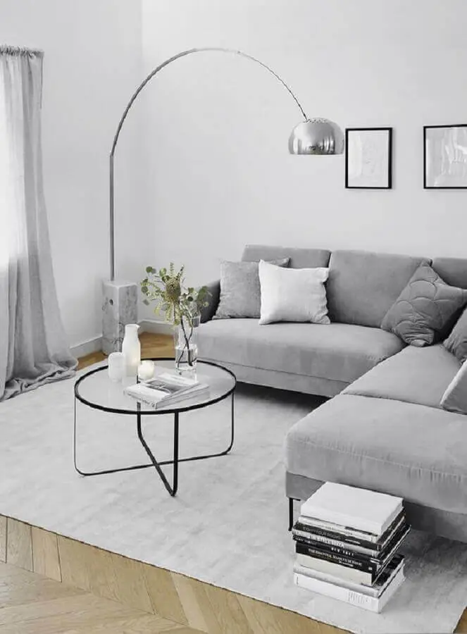decoração minimalista para sala de estar com sofá de canto cinza e luminária de chão Foto Westwing