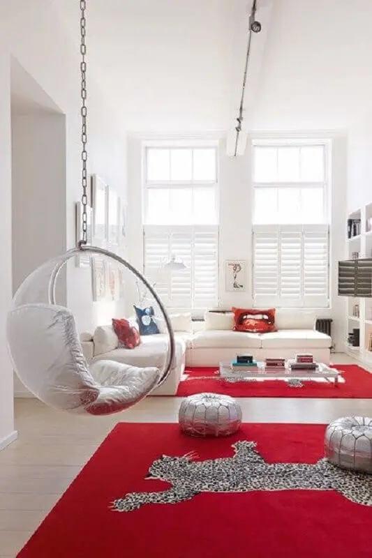 decoração moderna para sala vermelha e branca com cadeira de balanço suspensa transparente Foto House & Garden
