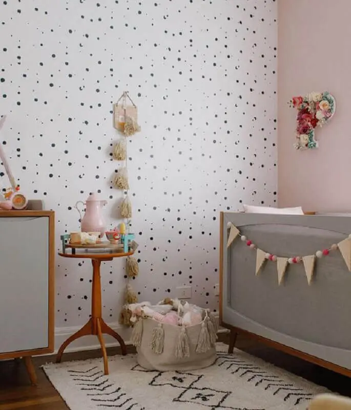 mesa de canto para quarto de bebê decorado com papel de parede de bolinhas e berço cinza Foto MamãeAchei!