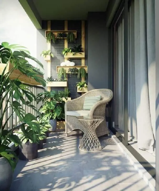 poltrona de vime para varanda cinza decorada com vários vasos de plantas Foto Home Designing