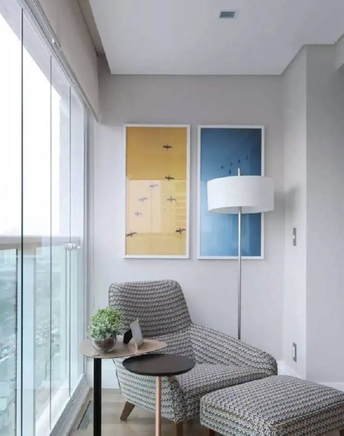 poltrona para varanda pequena decorada com abajur de chão e quadros de parede Foto Pinterest