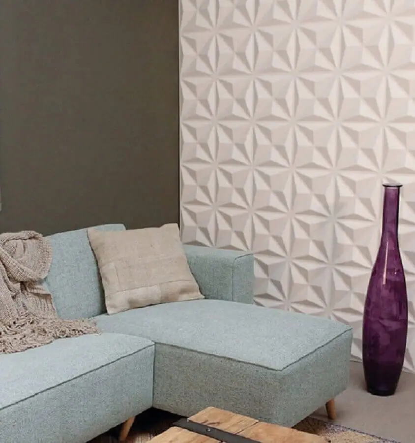 sala de estar decorada com sofá azul claro e revestimento 3d branco Foto Admirato