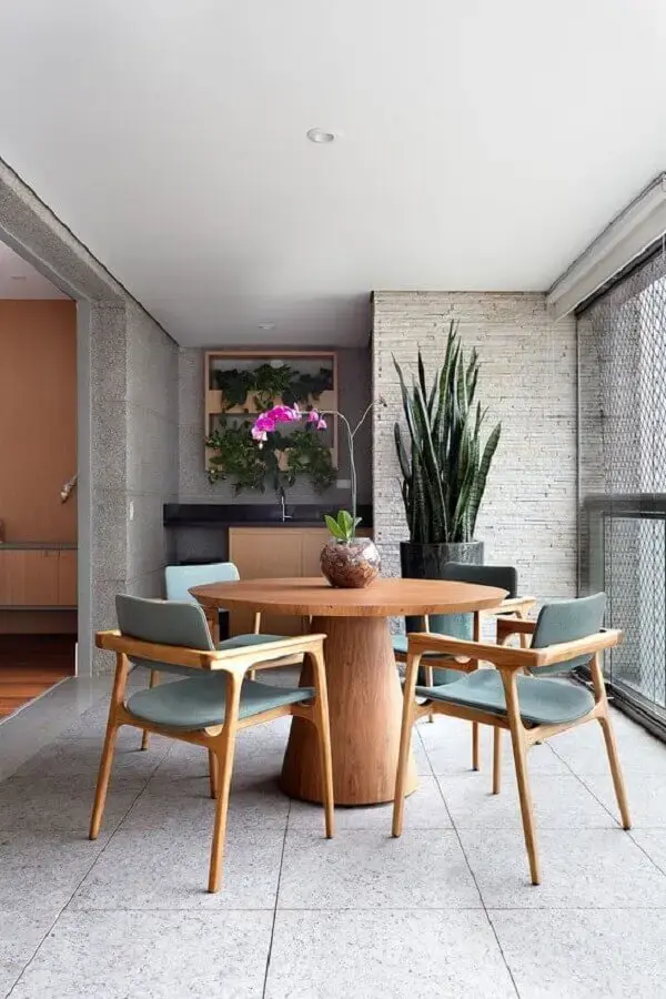 varanda de apartamento decorada com vaso grande de chão e mesa redonda de madeira Foto Casa de Valentina