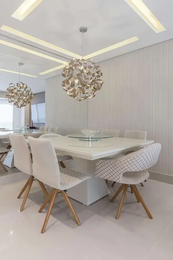 Decoração sofisticada para sala de jantar branca com parede espelhada e luminária de teto moderna