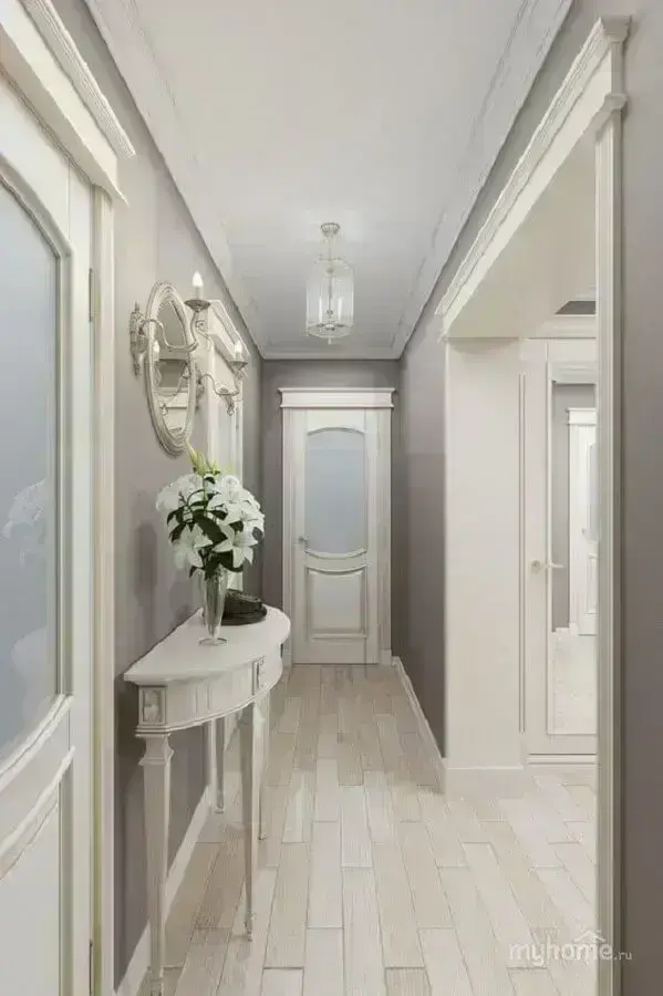 Decoração clássica para corredor com aparador branco pequeno