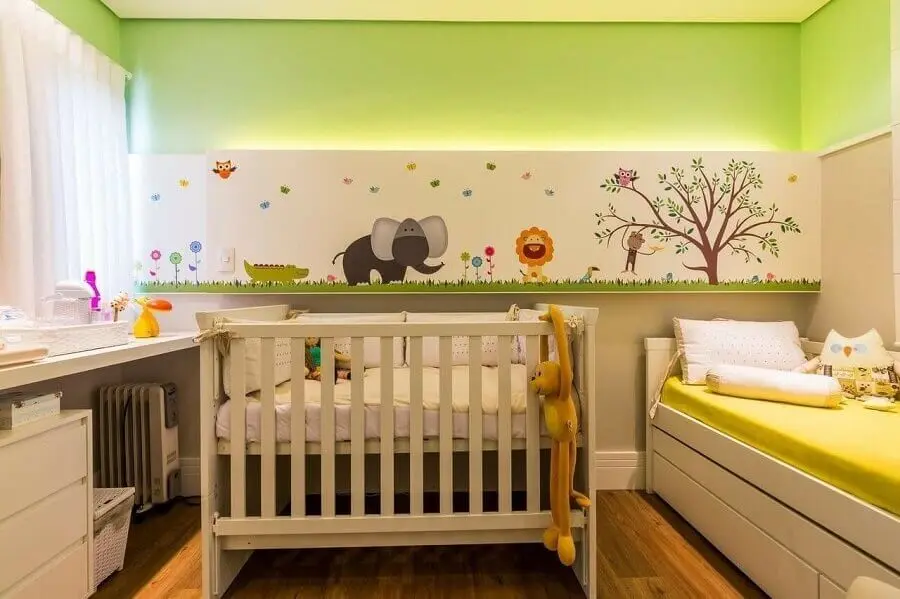 Decoração de quarto de bebê com parede cor verde claro e adesivos de animaizinhos