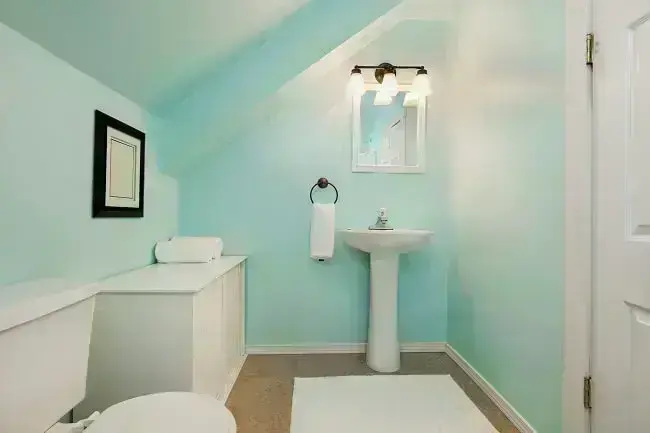 O azul discreto combinado com o branco das louças e móveis deixa o clima descontraído no banheiro social