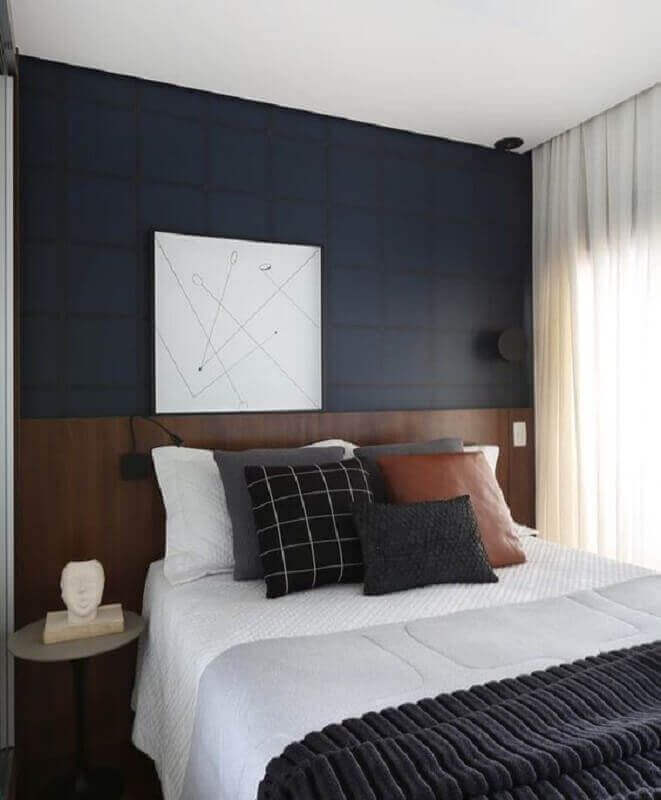 Almofadas decorativas para quarto decorado com papel de parede azul escuro e cabeceira de madeira