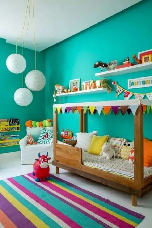 Parede cor verde água para decoração de quarto infantil com tapete listrado colorido