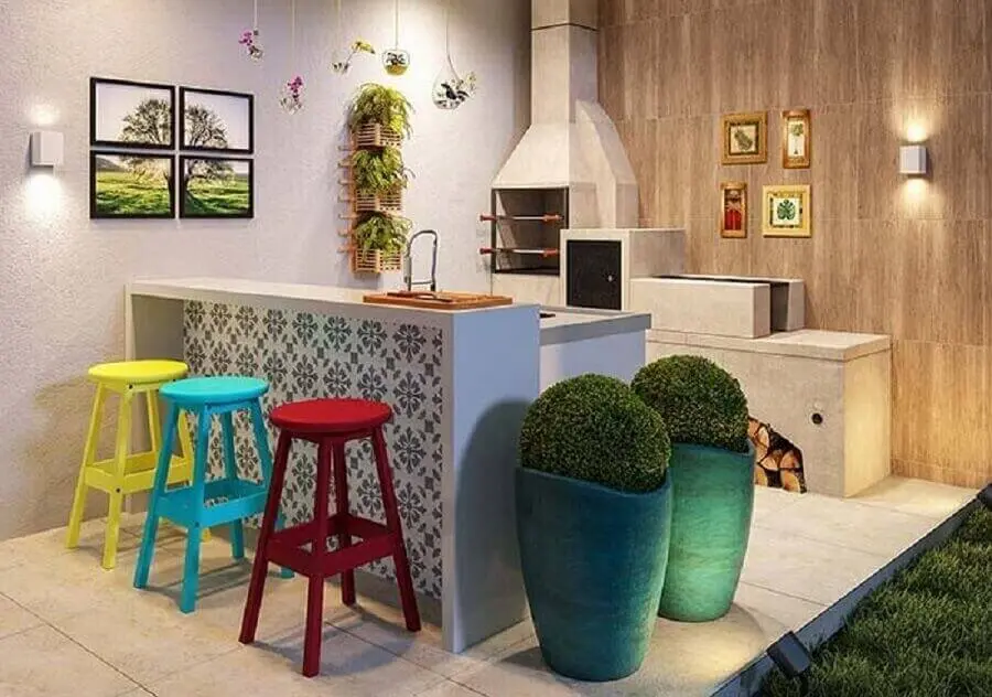 Área gourmet simples decorada com banquetas para bancada coloridas