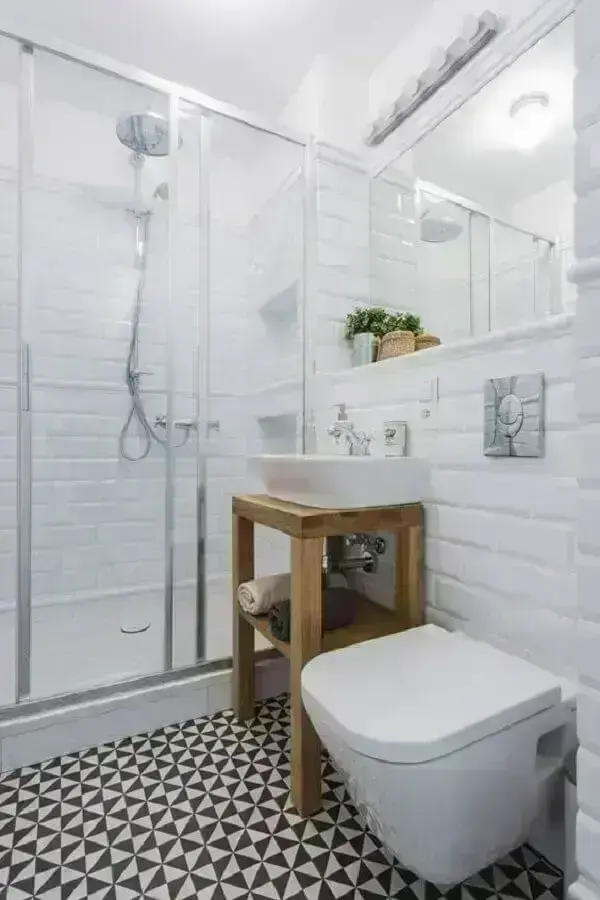 Azulejo de banheiro simples decorado com piso preto e branco e armário pequeno de madeira