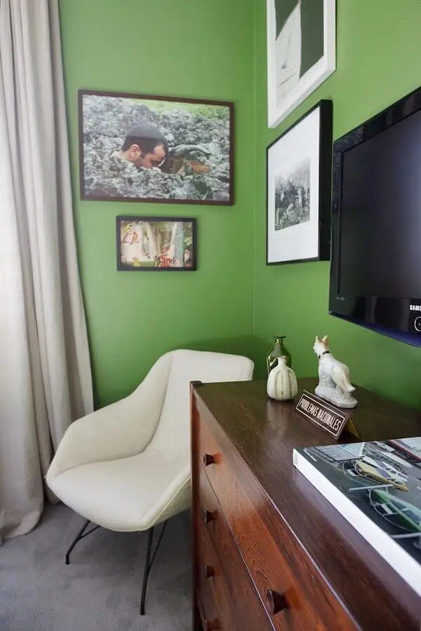 Decoração de quarto com parede cor verde oliva e cômoda de madeira