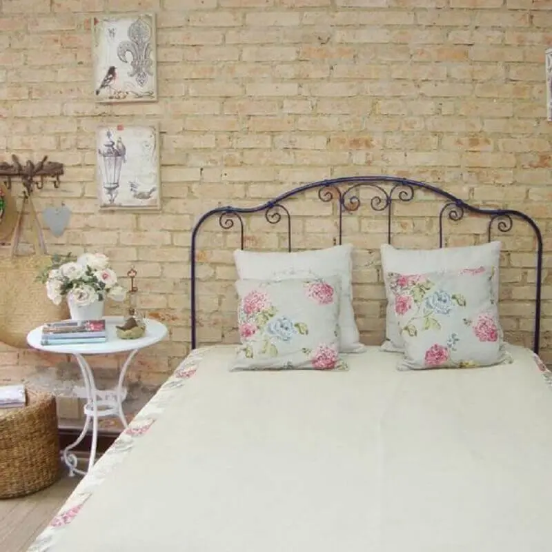 Quarto de casal simples e rústico decorado com parede tijolinho e cama de ferro