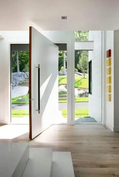 A porta pivotante branca é perfeita para decorar a entrada de casa