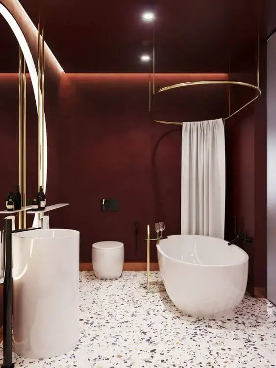 Banheiro com parede cor vinho e móveis brancos
