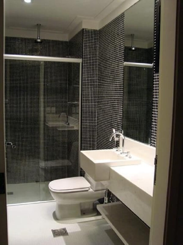 Banheiro com pastilha preta e chuveiro cromado no teto